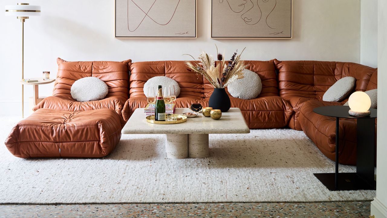 neutral area rug and tan brown leather togo sofas