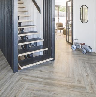 hallway with wooden parquet flooring and monochrome staircase