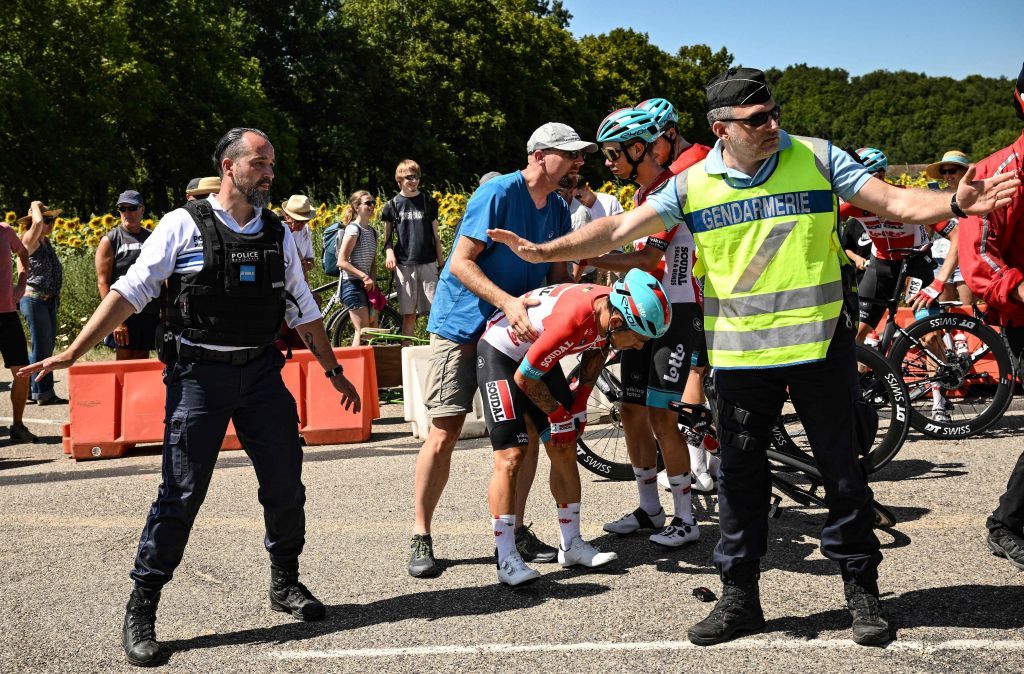 French gendarmes secure a perimeter as Lotto Soudal teams Australian rider Caleb Ewan C recovers from a crash cycles during the 13th stage of the 109th edition of the Tour de France cycling race 1926 km between Le Bourg dOisans in the French Alps and SaintEtienne in central France on July 15 2022 Photo by Marco BERTORELLO AFP Photo by MARCO BERTORELLOAFP via Getty Images