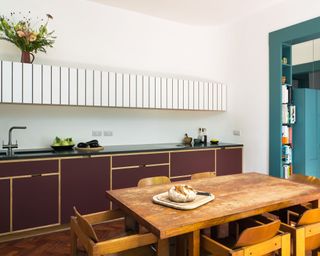 Modern kitchen with two tone cabinets and wood table and chairs