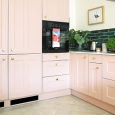 kitchen-diner with pink cabinets and built in oven