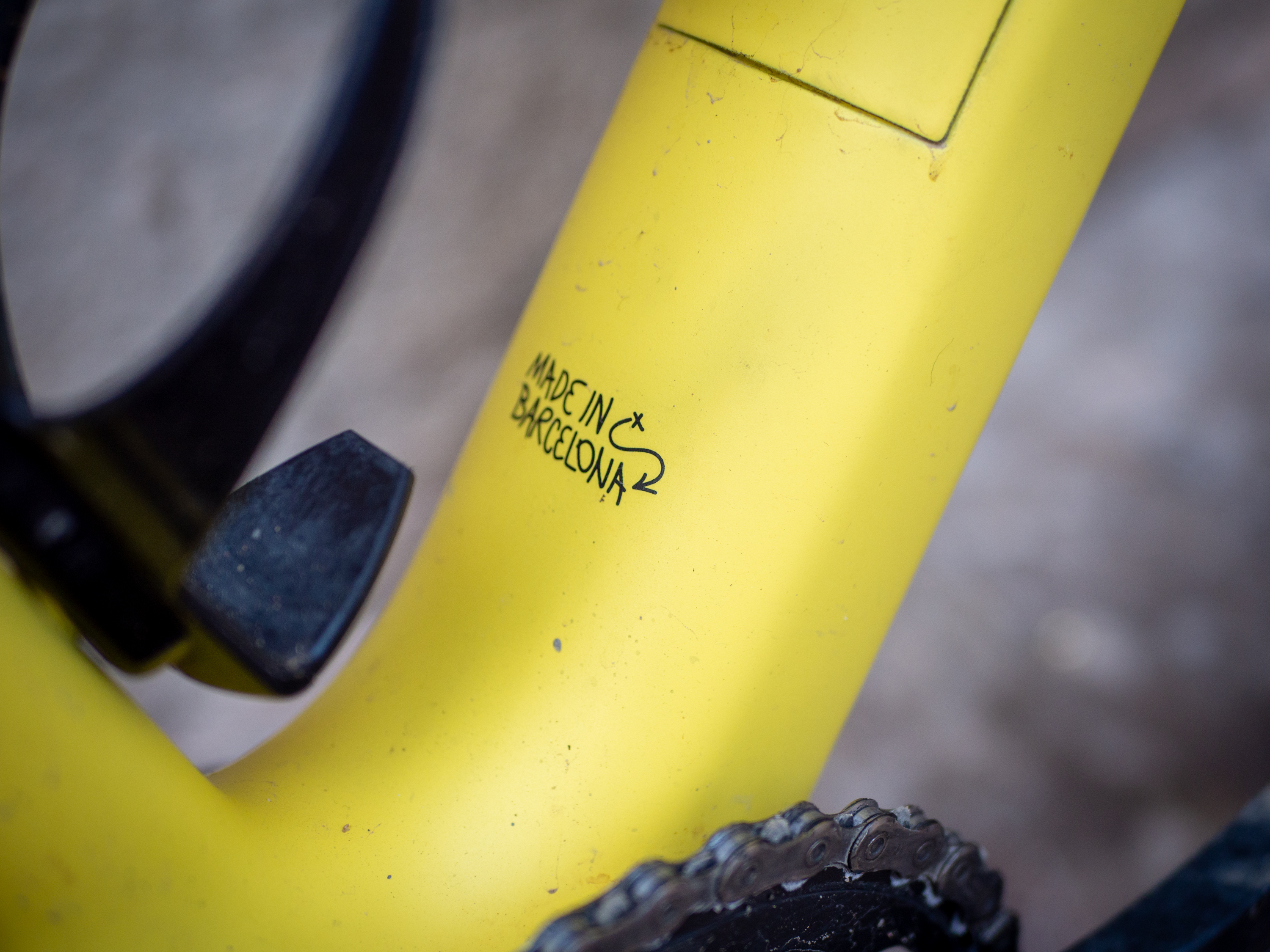 A yellow Guava Spot gravel bike leans against a wall