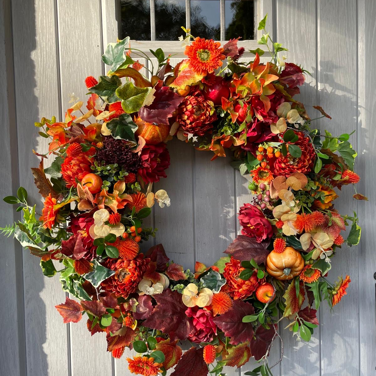 autumn wreath hanging on a white door