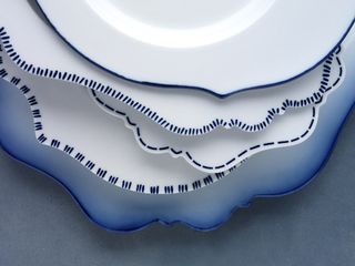 A stack of white crockery with a close-up of the blue details on the edges