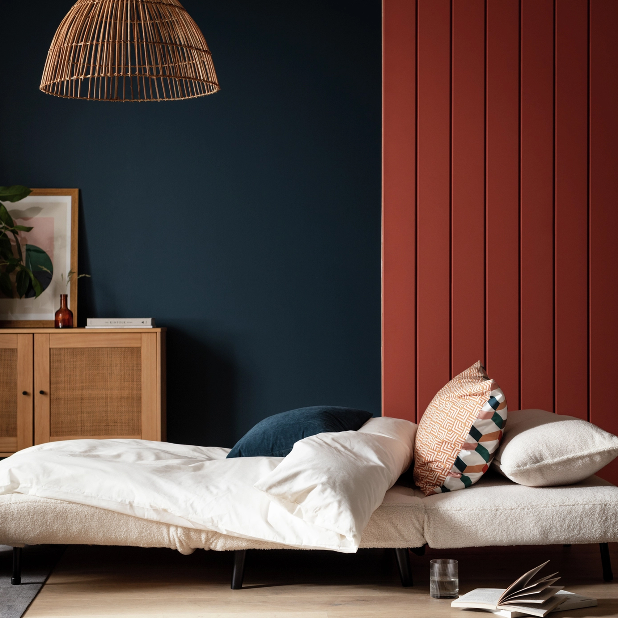 Habitat Roma chair bed in white boucle against a navy and red backdrop