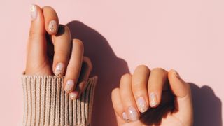 Hands with cream, glittery nail polish