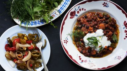 A bowl of spice beans topped with yoghurt and herbs