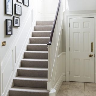 hallway staircase with photo frames on wall