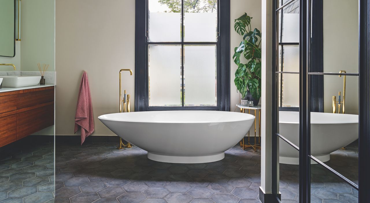 bathroom with mirrored glass panel and freestanding bath