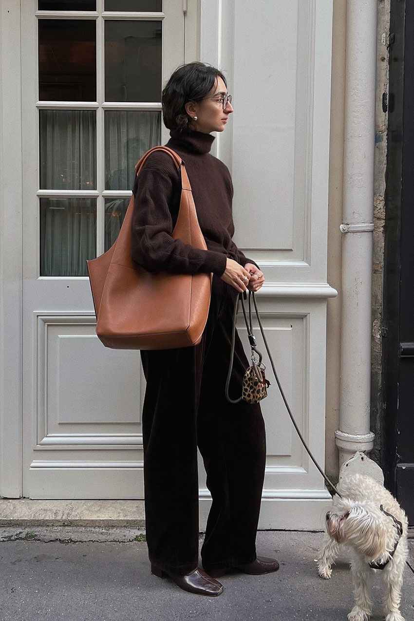 a woman wearing a brown slouchy bag
