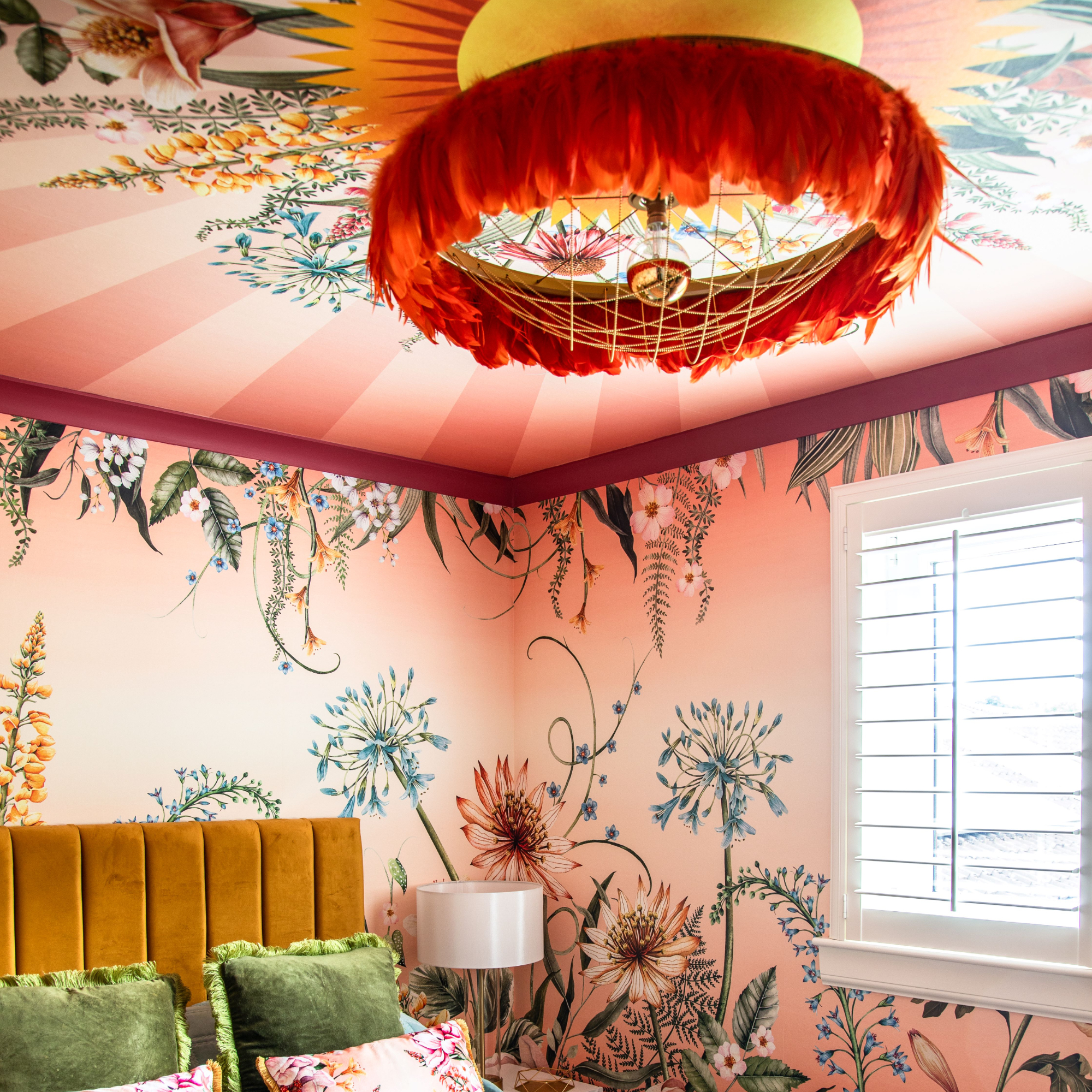 Pink, floral ceiling and wall mural in bedroom with large pendant lighting