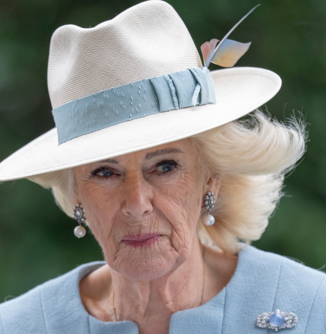 Queen Camilla wearing a fedora with a blue band and pale blue coat