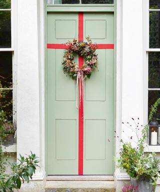 Outdoor Christmas decor with ribbon around front door
