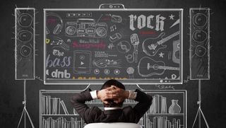 Man relaxing in front of chalk drawing of sound system and musical instruments