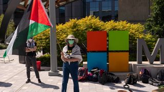 A demonstrator holds a Palestinian flag during a protest at the Microsoft Campus in Redmond, Washington, US, on Tuesday, Aug. 19, 2025.