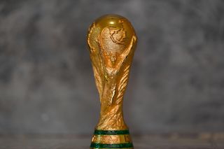 The World Cup trophy on a grey background