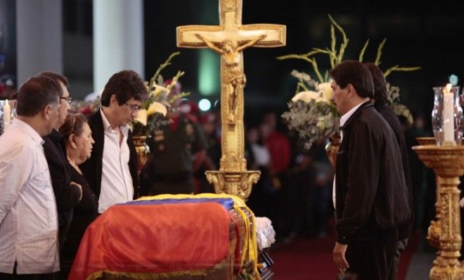 Hugo Chavez&amp;#039; family surround the late president&amp;#039;s flag-draped coffin on display during his wake on March 6.