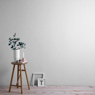 Twinkle grey star pattern wallpaper with a stool and vase of flowers