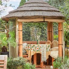 Tiki bar style summerhouse with dining table inside