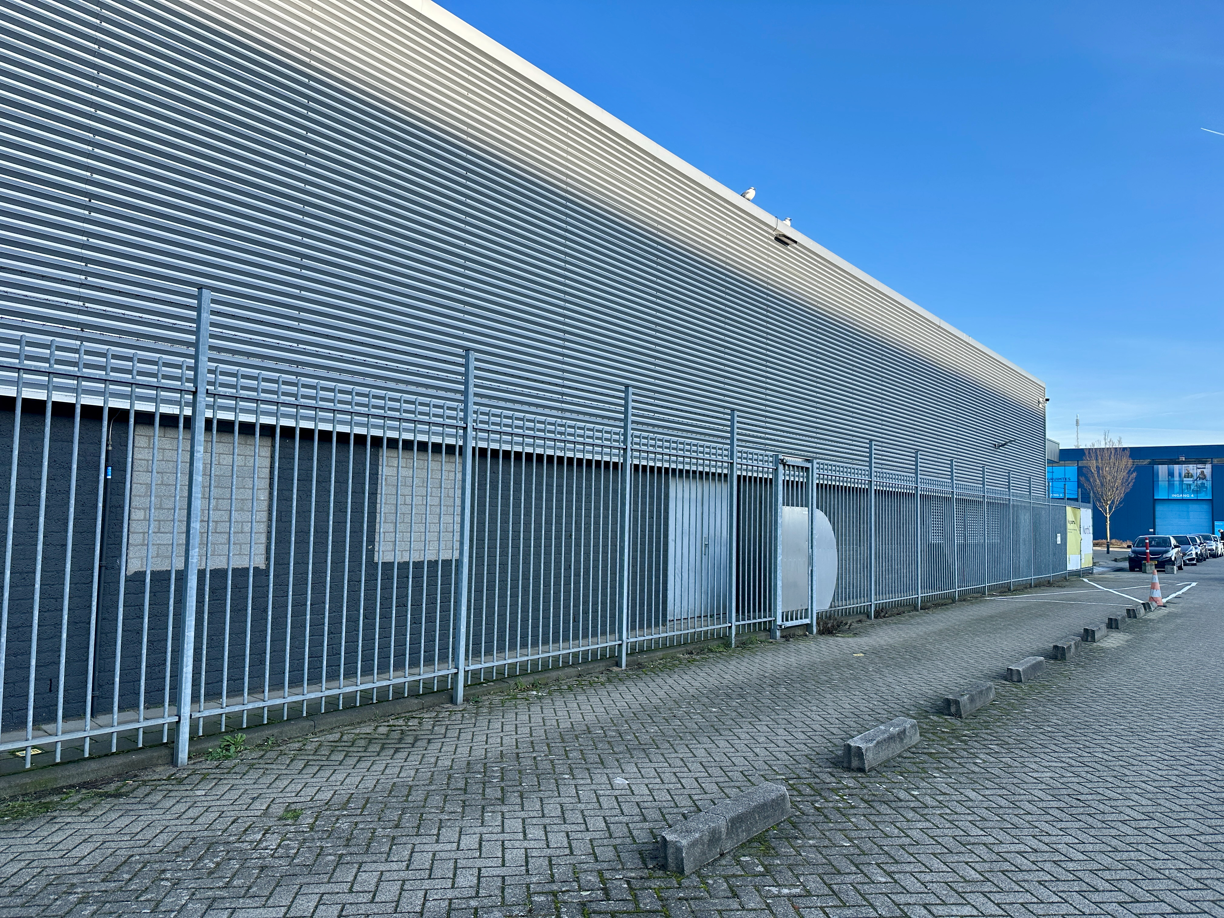 A large steel-grey data center building, which houses many servers farms