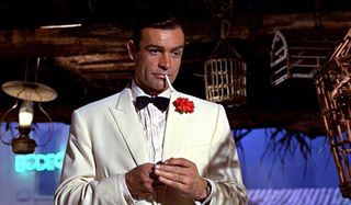Goldfinger Sean Connery, in a white jacket, lighting a cigarette