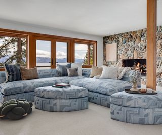 family living room with blue sectional and ottomans and stone fireplace