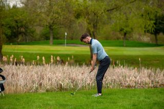 Dan Parker hitting an approach shot to a green while wearing the True Linkswear All Day Joggers