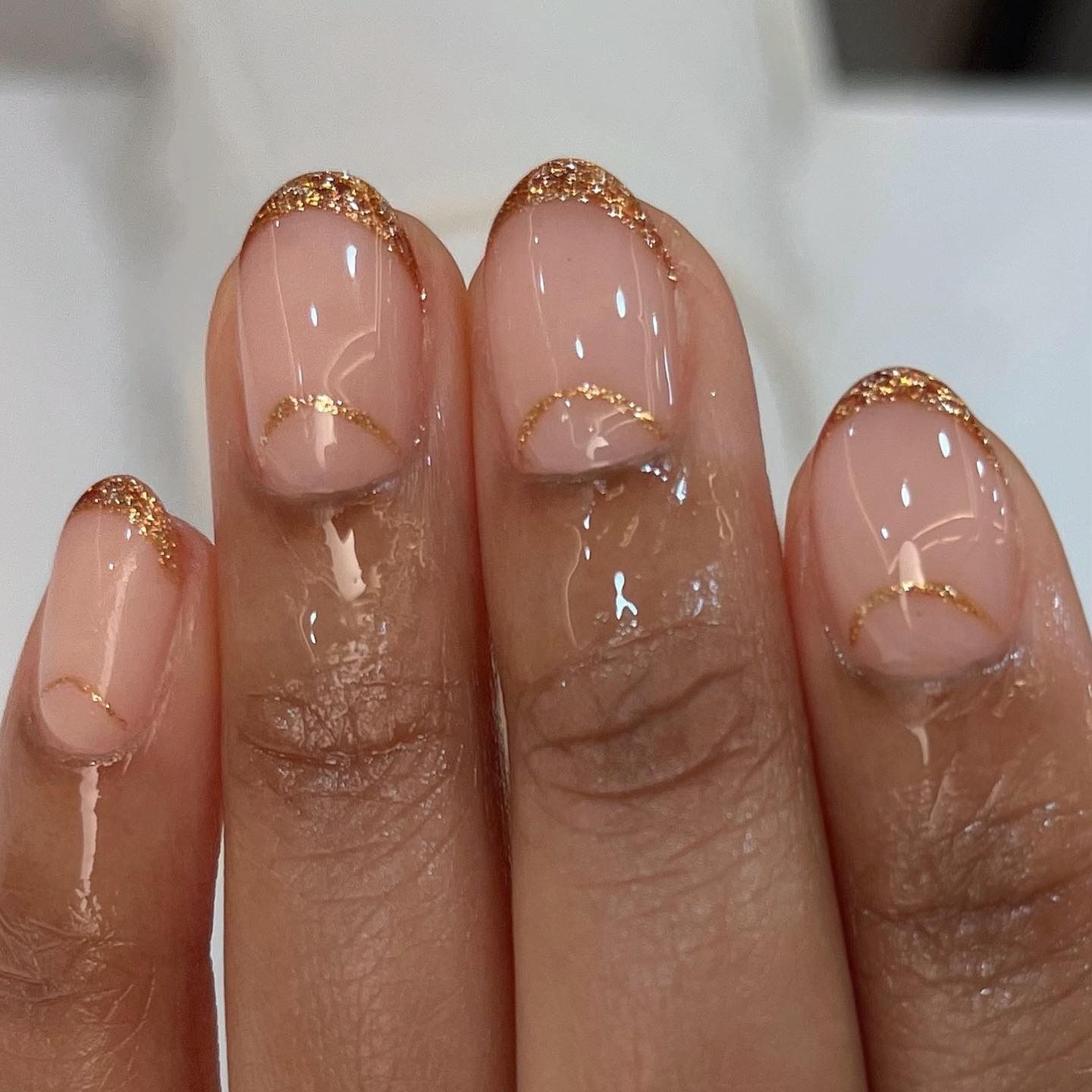A sparkly cinnamon French tip nail design