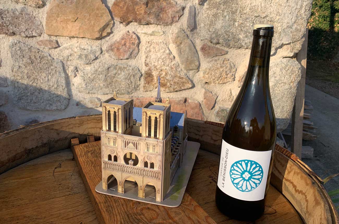 Bottle of Domaine de La B&eacute;nisson-Dieu wine and model of Notre-Dame Cathedral