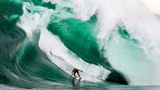 Surfer riding massive waves in Tasmania, Australia