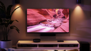 An Amazon Fire TV QLED in a living room next to a plant showing an AI generated image of river flowing through a canyon.
