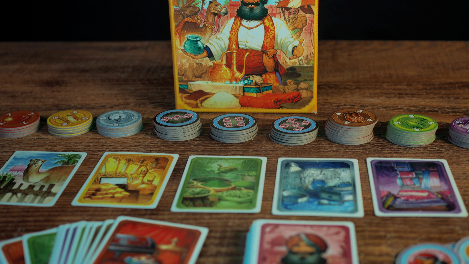The box, tokens, and cards of Jaipur laid out on a wooden table
