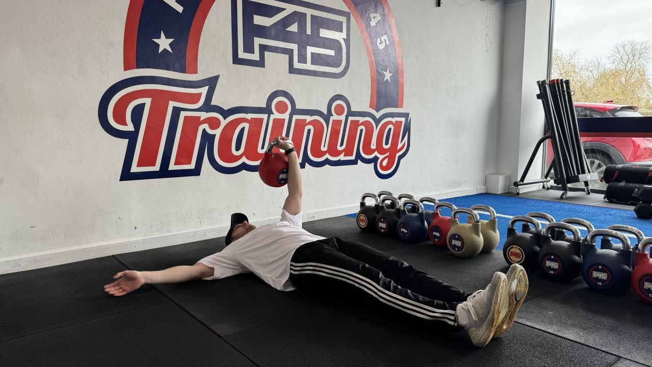F45 personal trainer demonstrates a single arm crunch