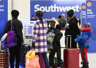 Southwest Airlines passengers queue at baggage check-in at George Bush Intercontinental Airport, Tuesday, Nov. 21, 2023, in Houston