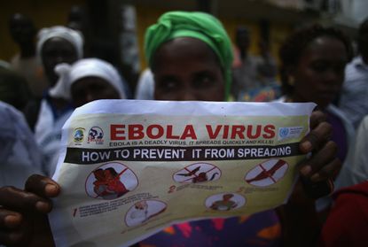 A woman reads a pamphlet on Ebola.