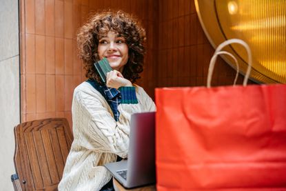 A woman using the best credit cards for cashback after shopping