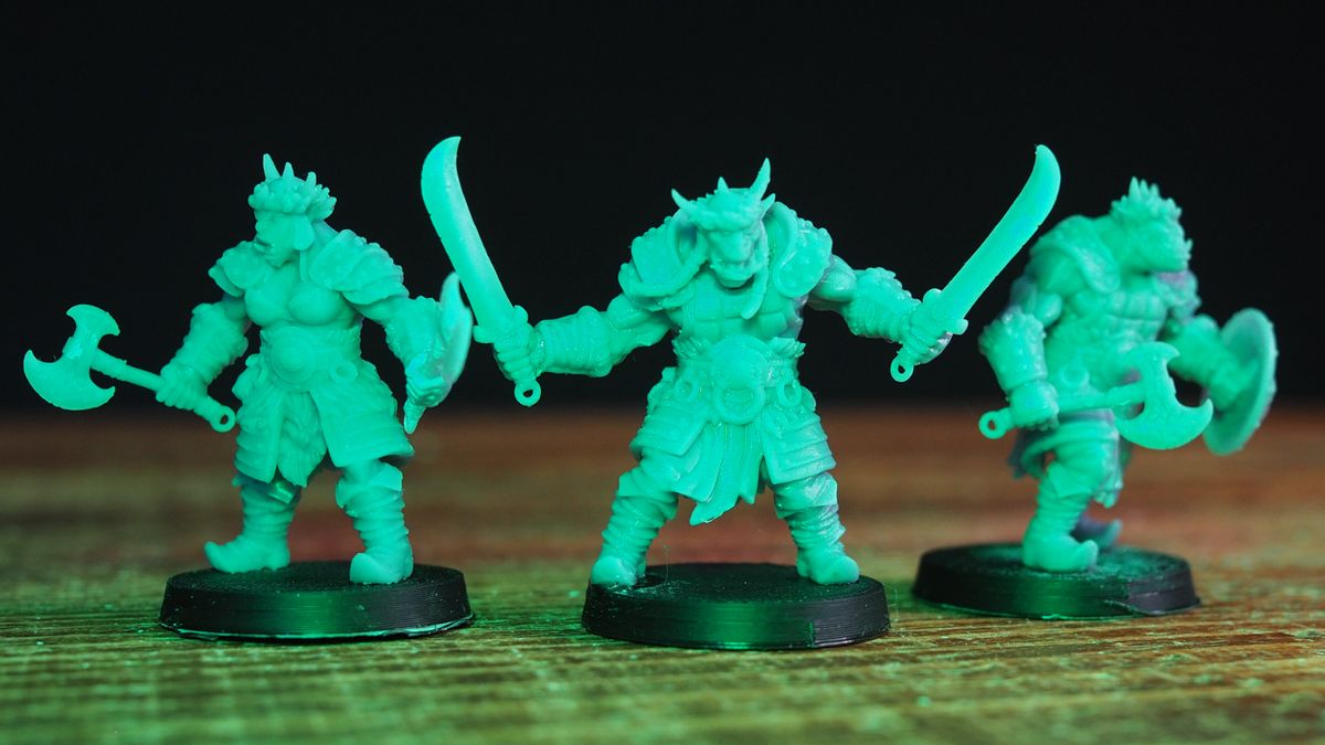 Orc miniatures in poses on a wooden table