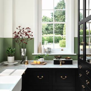 country kitchen ideas, small kitchen with black units, marble worktops, green painted splash back, view to garden