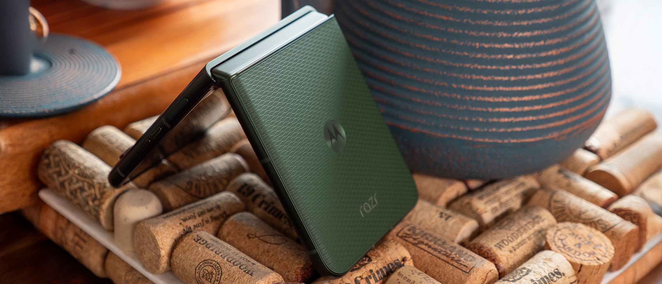 A green Motorola Razr Plus 2026 in tented mode, showing the vegan leather back