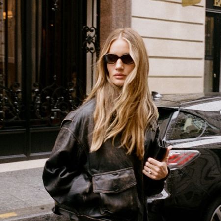 Rosie Huntington-Whitely with long hair wearing sun glasses and a leather jacket