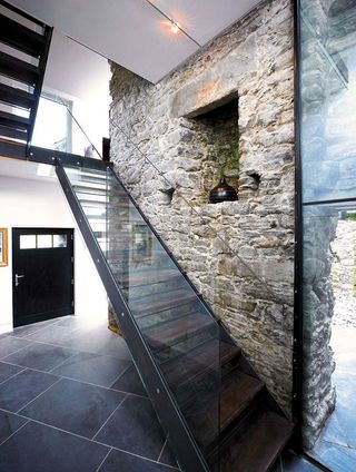 industrial glass and metal staircase in stone cottage extension