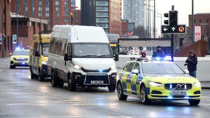 A line of police vehicles delivering/escorting Axel Rudakubana for sentencing in 2025