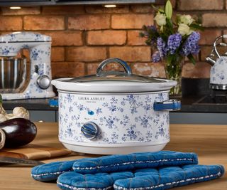 A Laura Ashley & VQ slow cooker on a wooden countertop