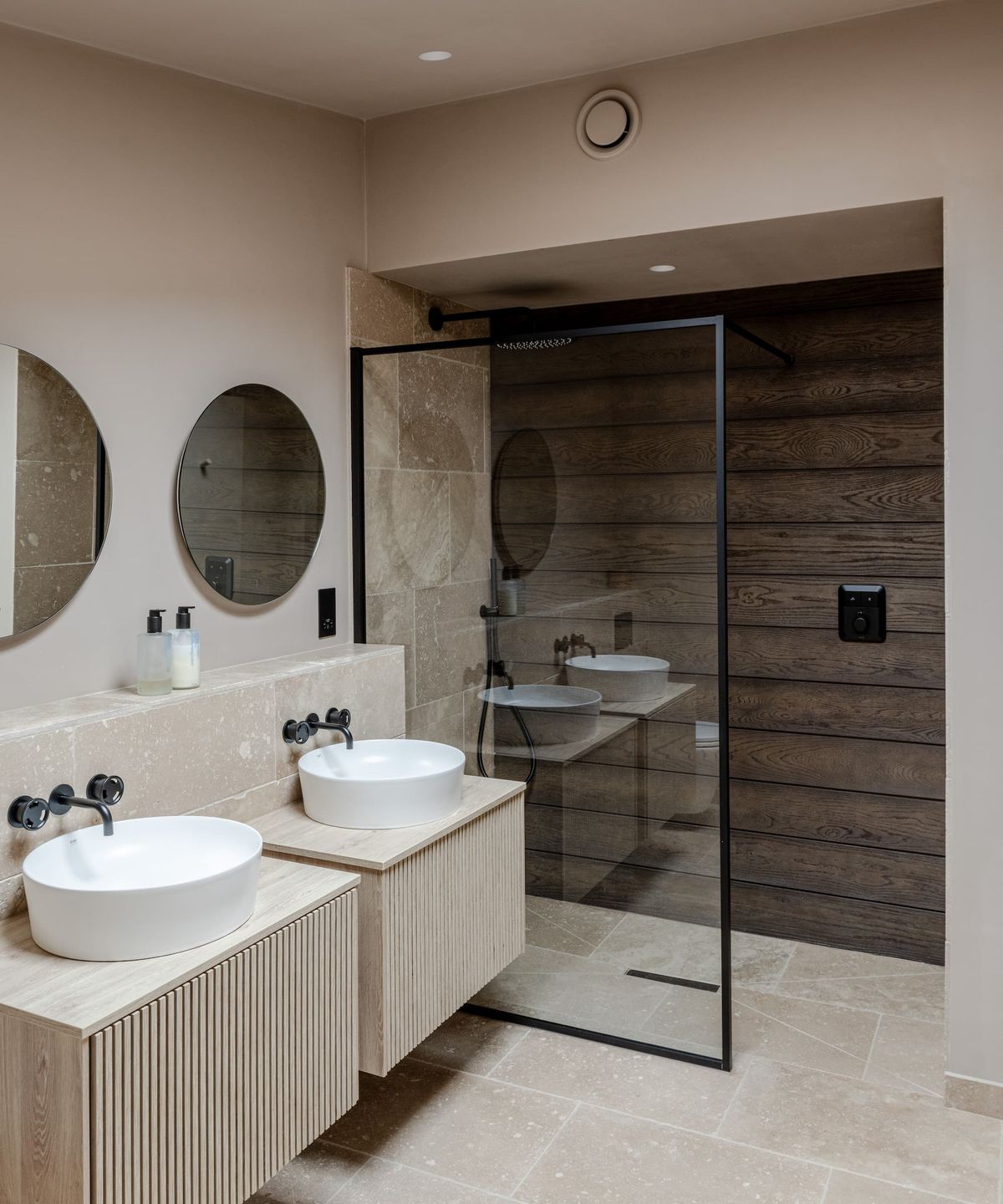 A white bathroom with his and her sinks and a walk in shower