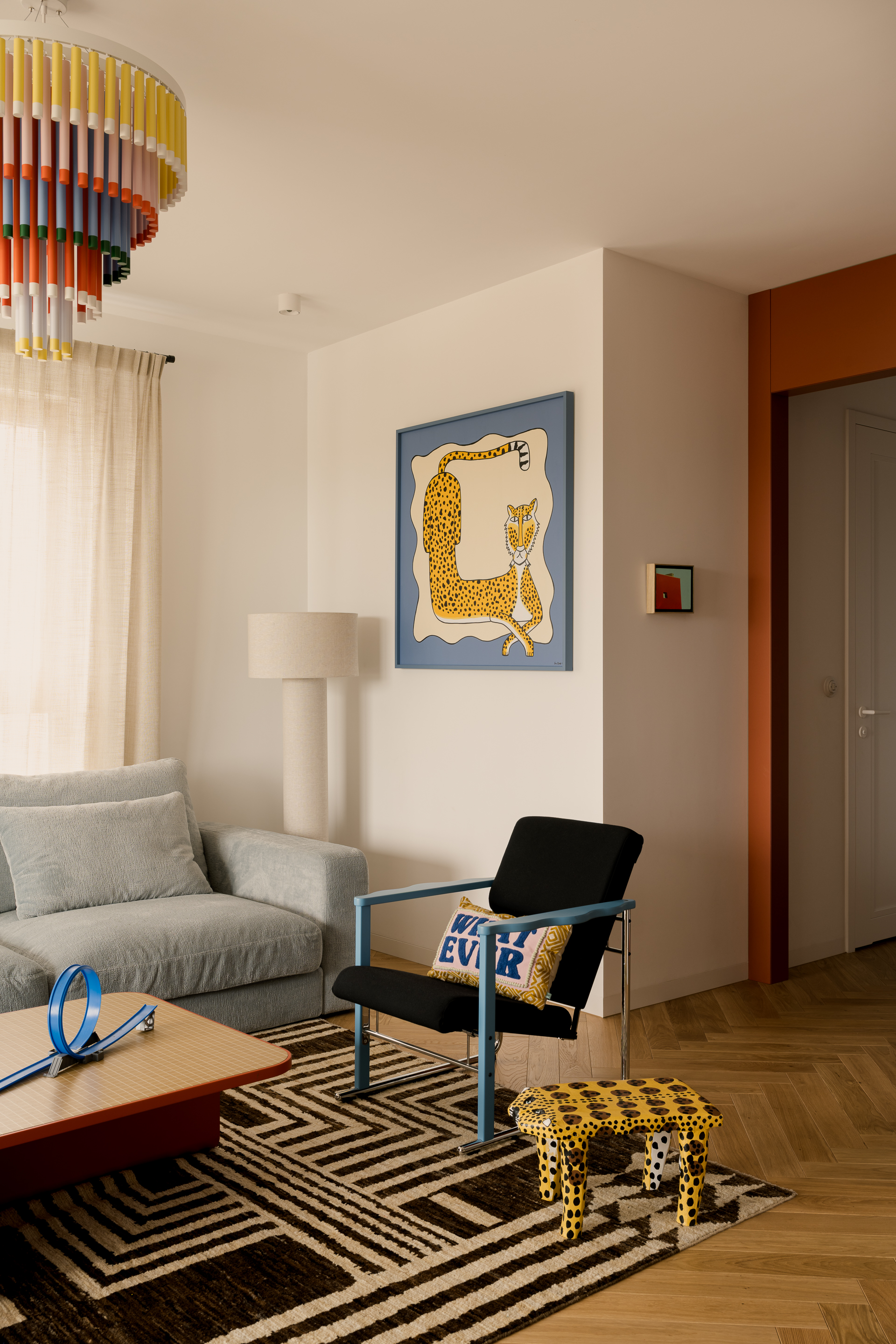 A living room in blue and terracotta, with a recurring leopard-like character
