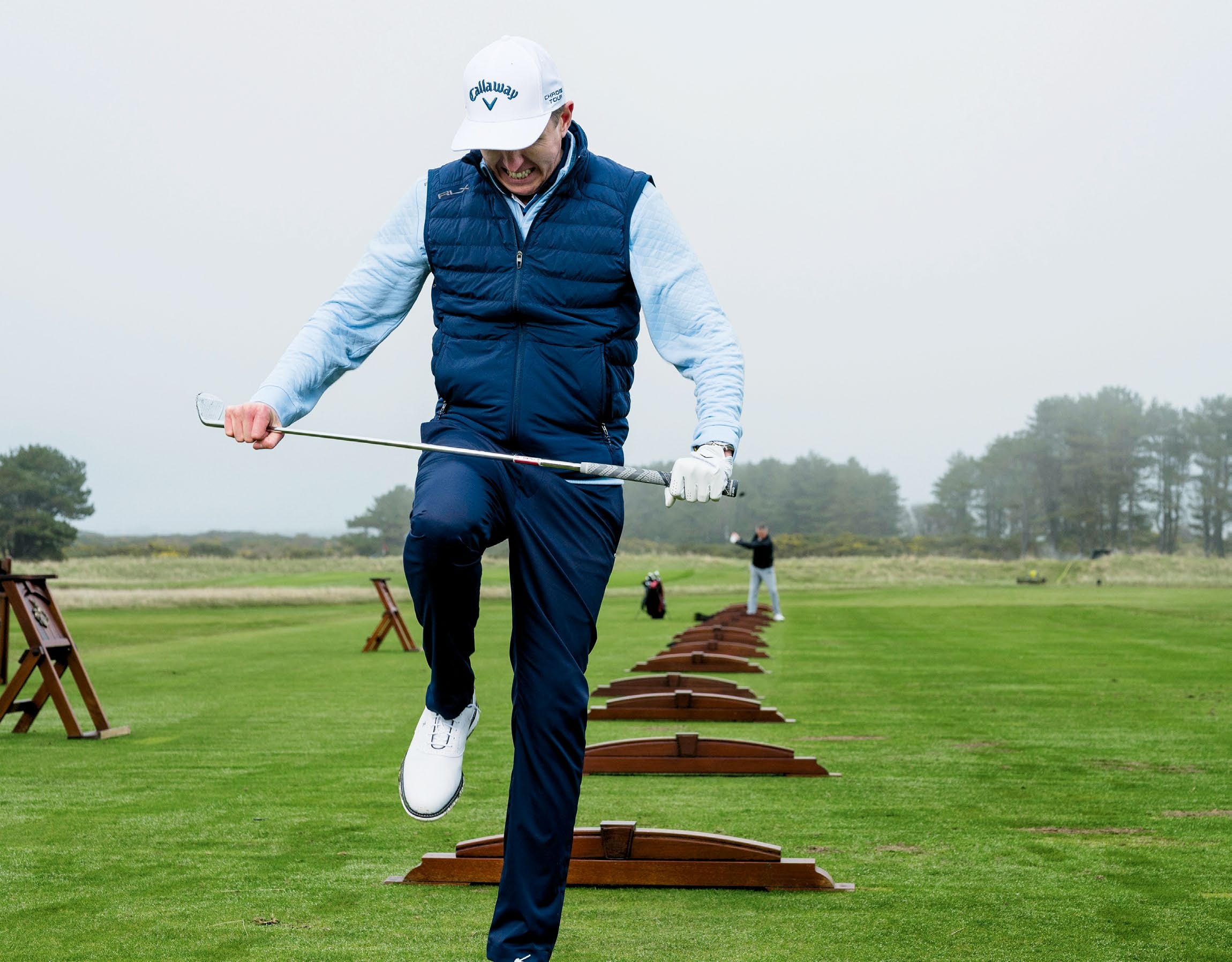 Ben Emerson snapping a golf club over his knee in frustration on the driving range