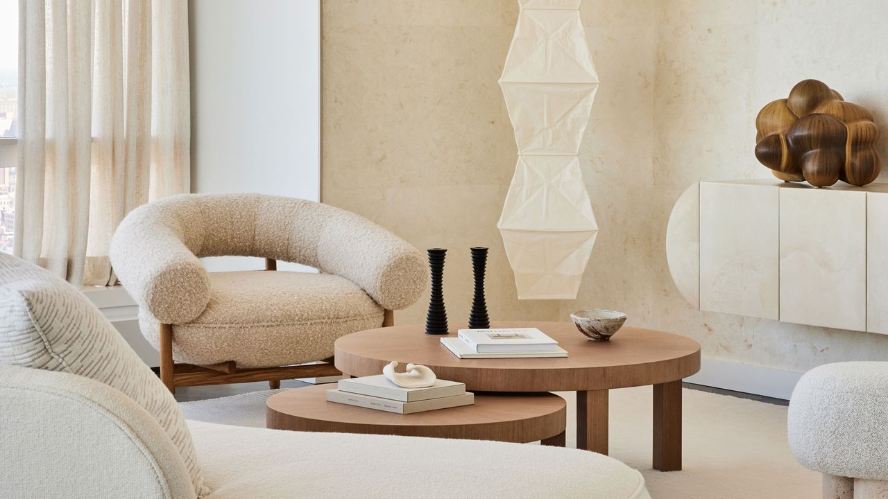 a beige living room with a noguchi pendant light and boucle chairs