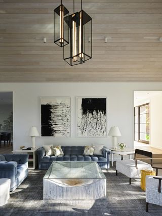 light and large living room with big modern art on the walls a neutrally colored furniture