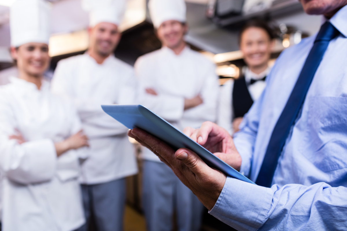 Restaurant manager in kitchen with tablet