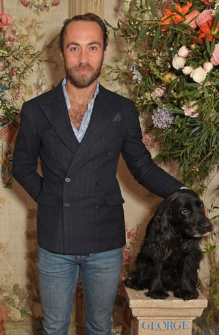 James Middleton wearing a blazer and petting a black dog